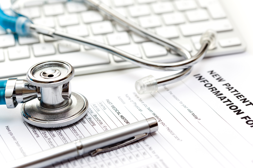 stethoscope and pen on a new patient form with a keyboard in the background